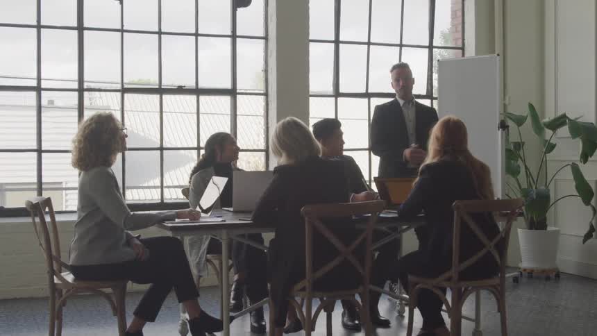 Man gives a presentation to coworkers in an office