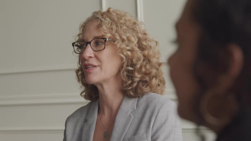 A woman nods and talks at a meeting