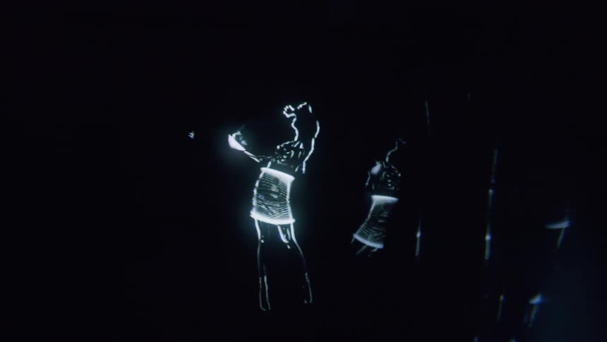 The hologram is of a woman dancing across the screen