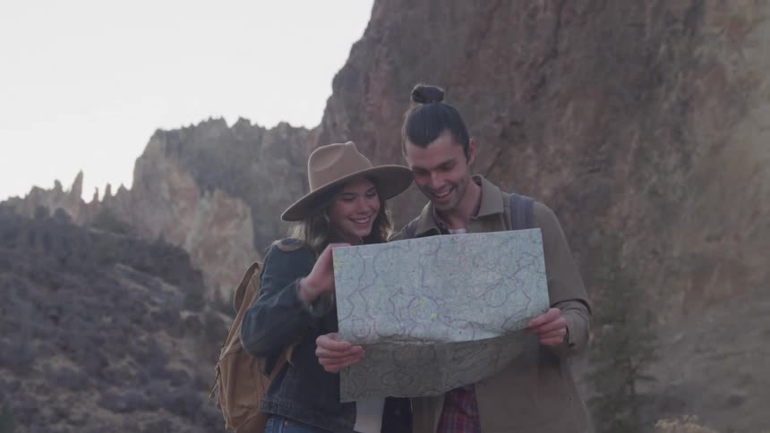 A man and women look at a map while hiking