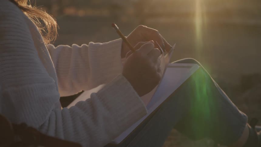 Girl sitting writing in a notebook