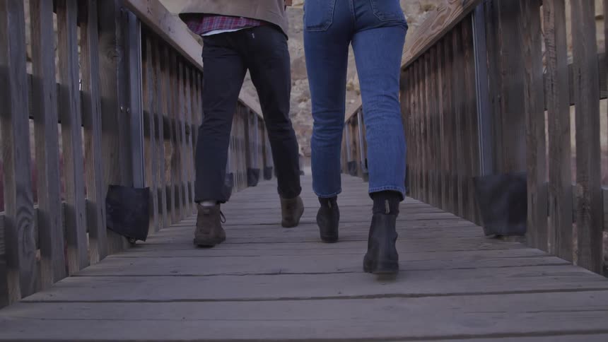 Two women hike over the wooden bridge