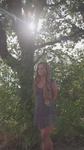 A woman is smiling in front of the tree