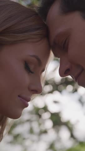 Happy husband and wife with their eyes closed with their heads resting between them