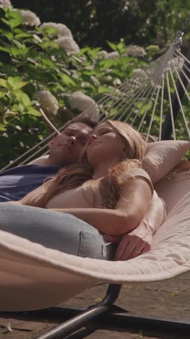 A couple naps together in a gently swaying hammock