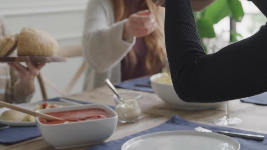 Family passes a pasta dinner around the dining table