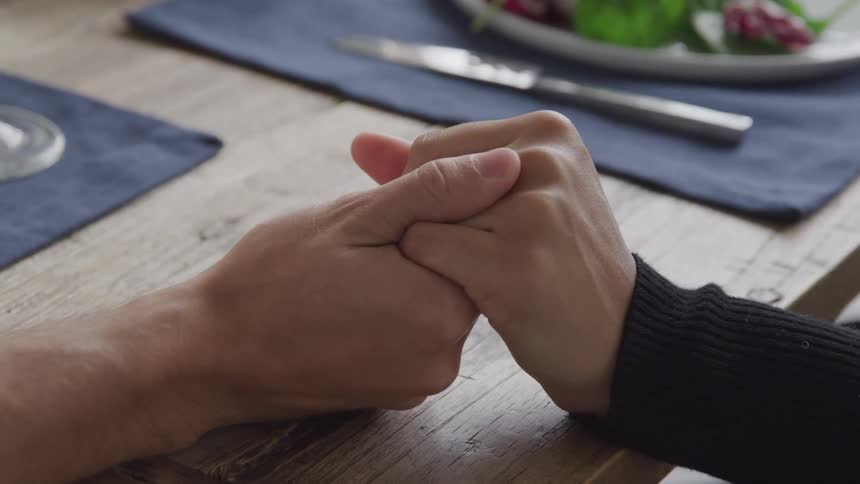 People holding hands over a table