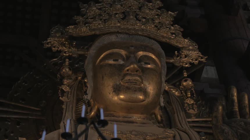 A golden statue sits in a dark area