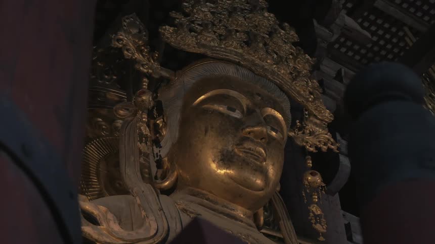 A large gold buddha sits in this dark area
