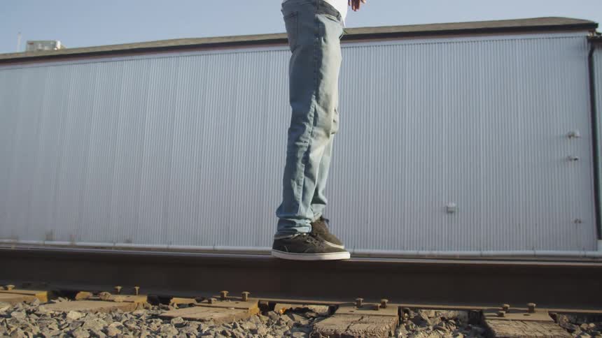A man is balancing on the track rail