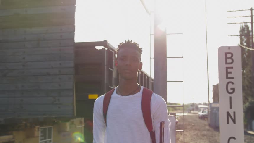 Boy looking toward the camera behind passes a cargo load