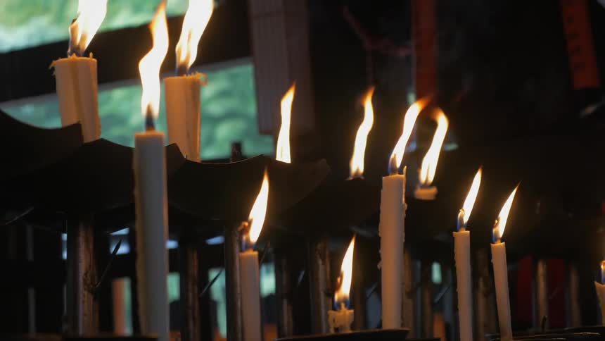 A row of candles smoke and burn