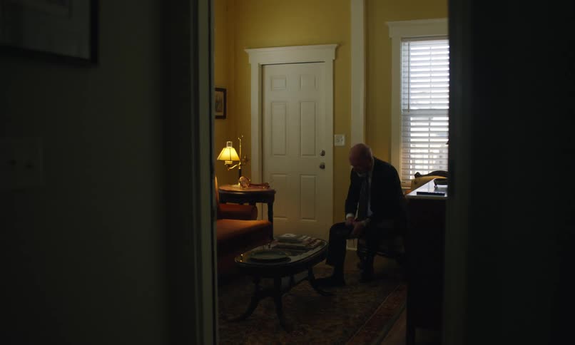 Man puts on his shoes and ties the laces in his living room