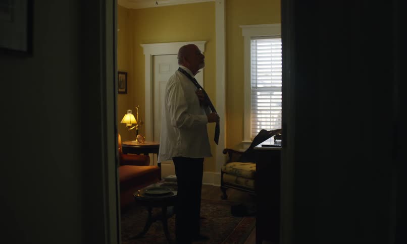 Elderly man dressing up putting on a tie