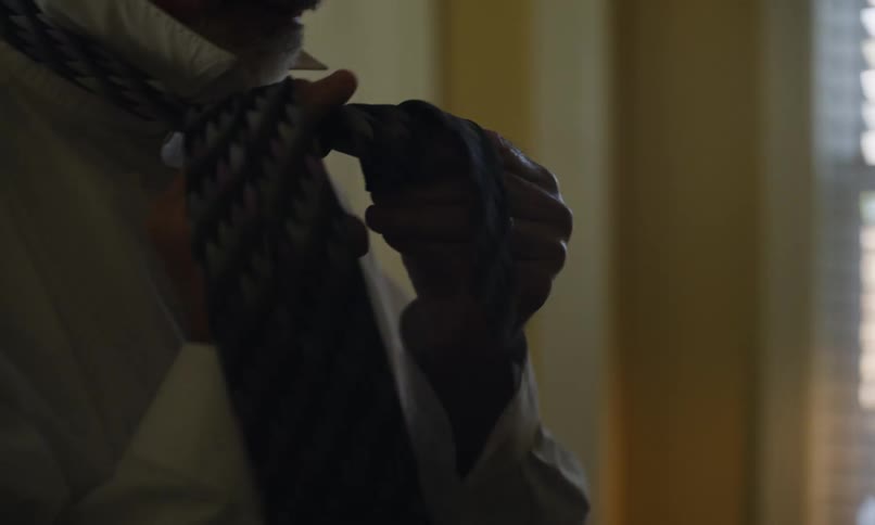 Man ties a necktie around his neck
