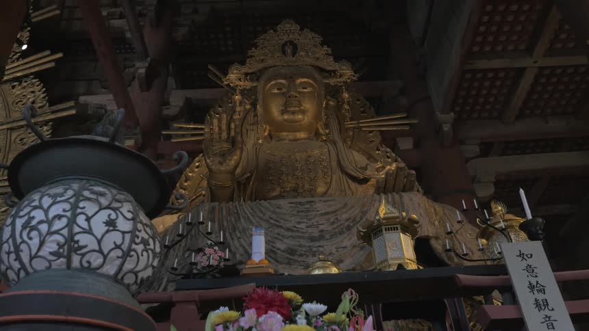 A large gold statue is a shrine in this dark area