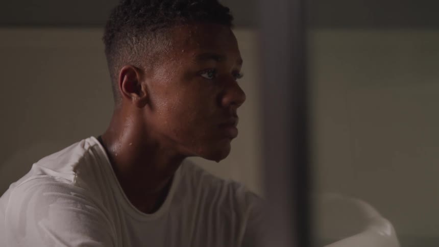 A teenager is sitting in the bathtub