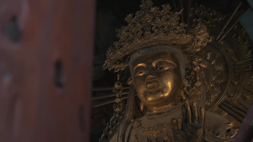 Golden statue that seems to be part of a wall