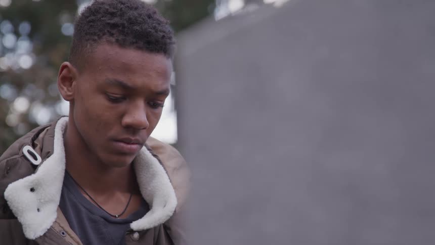 Sad boy in front of someones grave