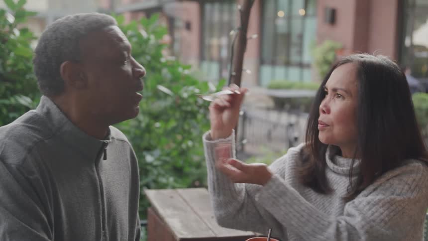 Woman feeding a man with a fork some food