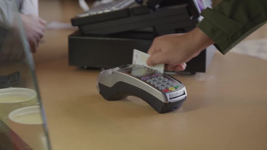 Cashier slides a credit card reader for a patron to swipe his card
