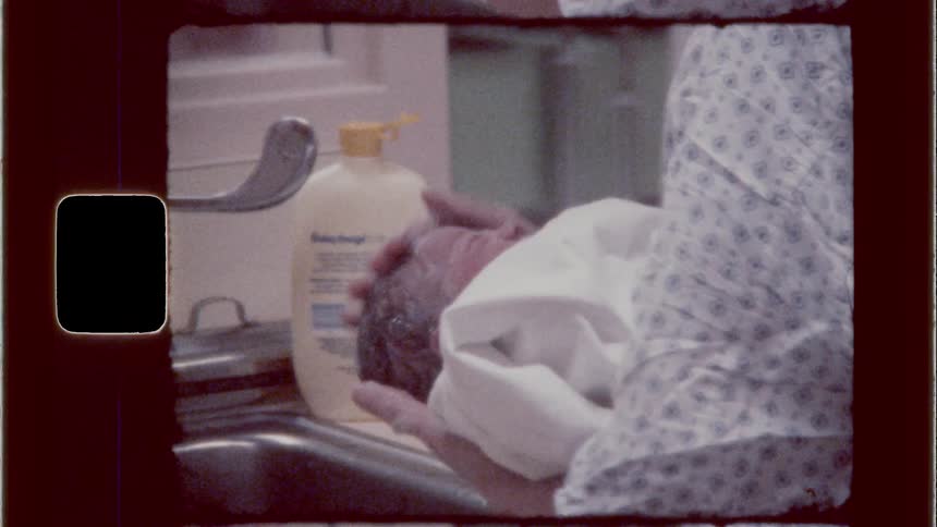 Nurse washing newly born baby in the hospital