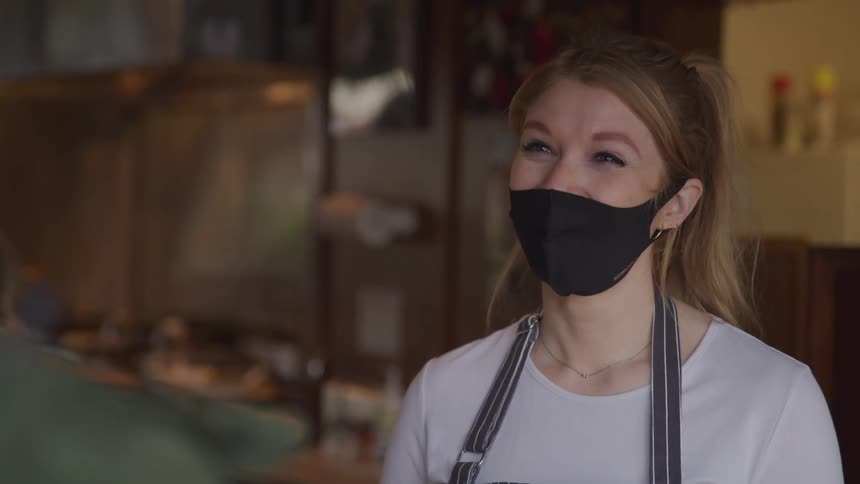 Saleswoman with mask talking to a customer