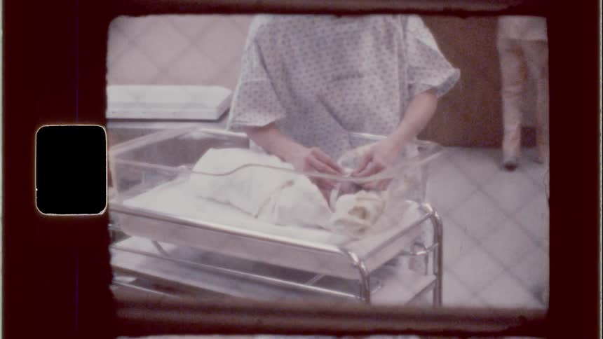 Nurse tends to an infant in the hospital nursery