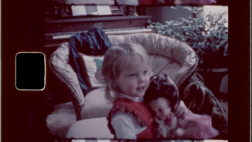 Toddler girl plays with a doll while talking