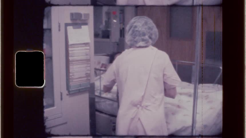 Nurse pushing patients hospital bed into room
