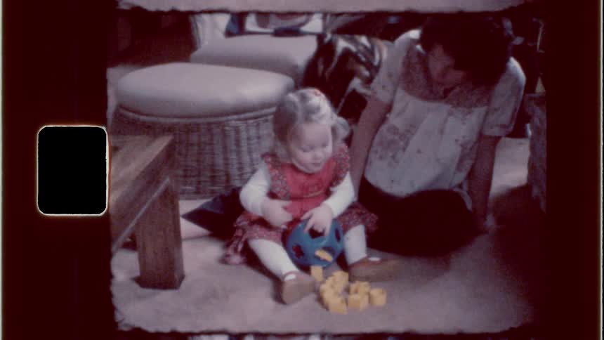 Mom watching her daughter play with toys