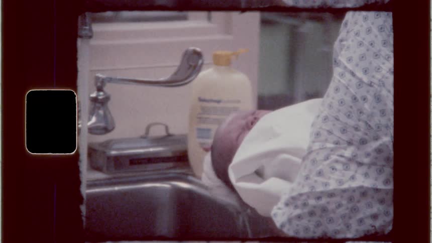 Nurse washes a babys hair in the sink