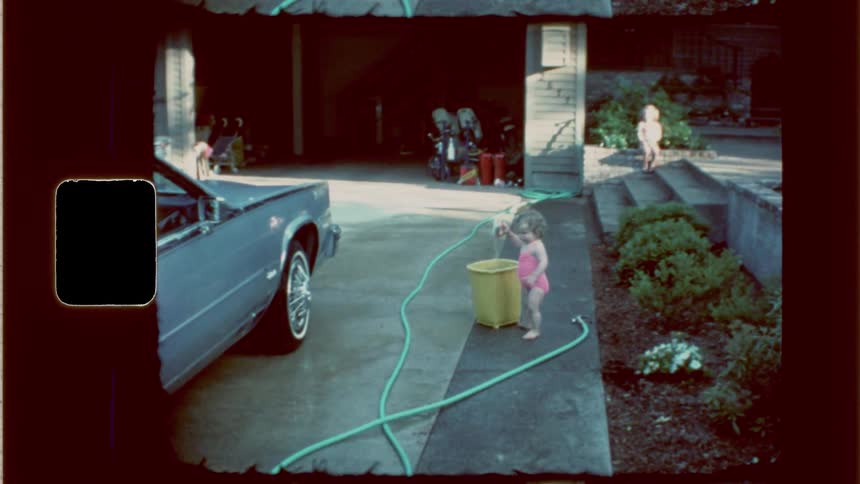 Children are playing with water in the driveway