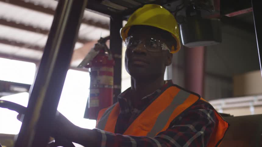 Man in a hard hat sits in a forklift