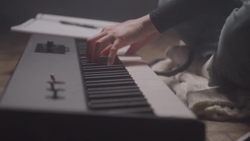A woman is playing the keyboard at home