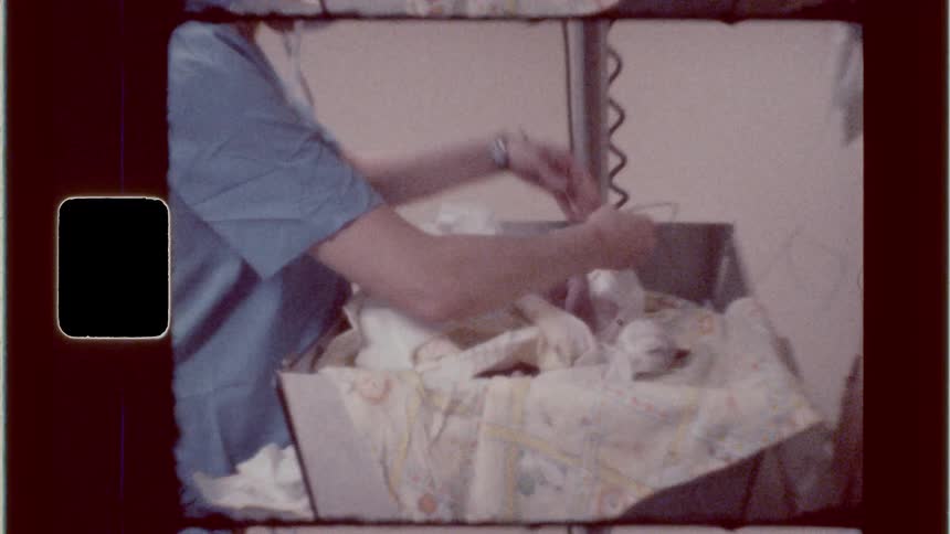 Healthcare workers attend to a newborn using a bulb syringe for suction