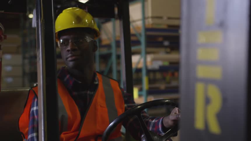 Worker with all the protection driving a forklift