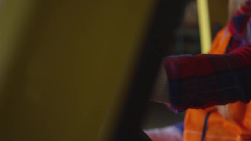 Woman grips the steering wheel while sitting in a forklift