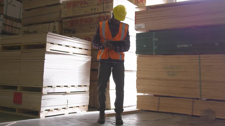 A worker is writing in the warehouse on a sunny day