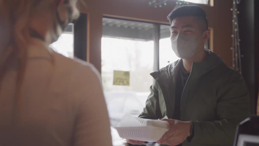 Customer picking up to go order from restaurant
