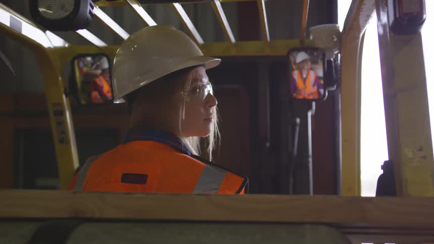 Girl on top of a work vehicle turning her gaze backward