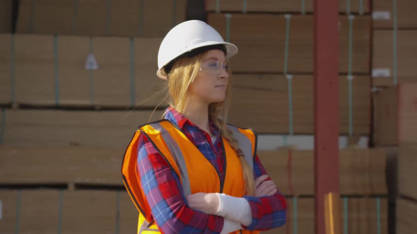 Girl in work uniform with her hands folded looking away