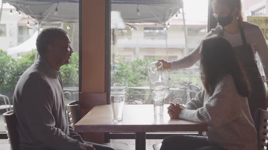 A waitress pours water for the customers