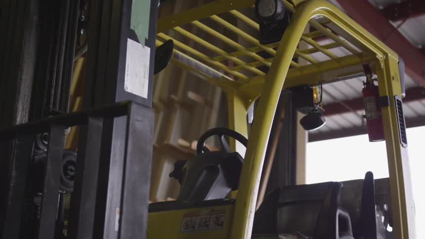 A forklift is parked in the empty warehouse