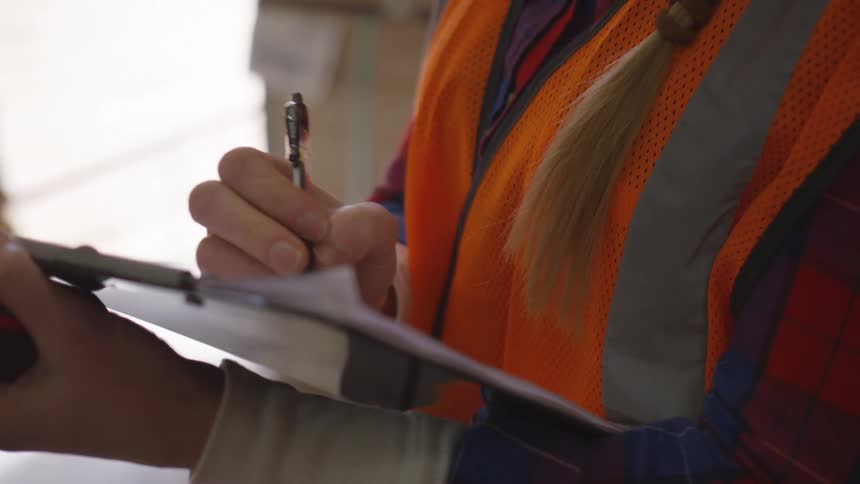 Worker writing on sheets of paper