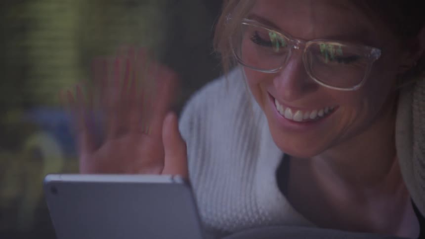 Woman having a video call on her smartphone waves at it