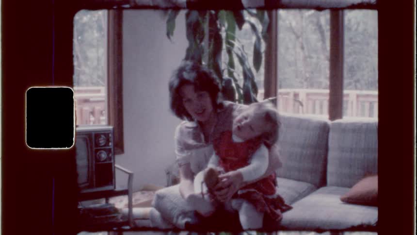 Mom putting slippers on her little daughter