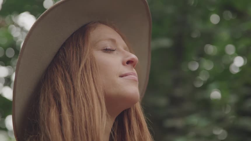 A woman is smiling with her eyes closed
