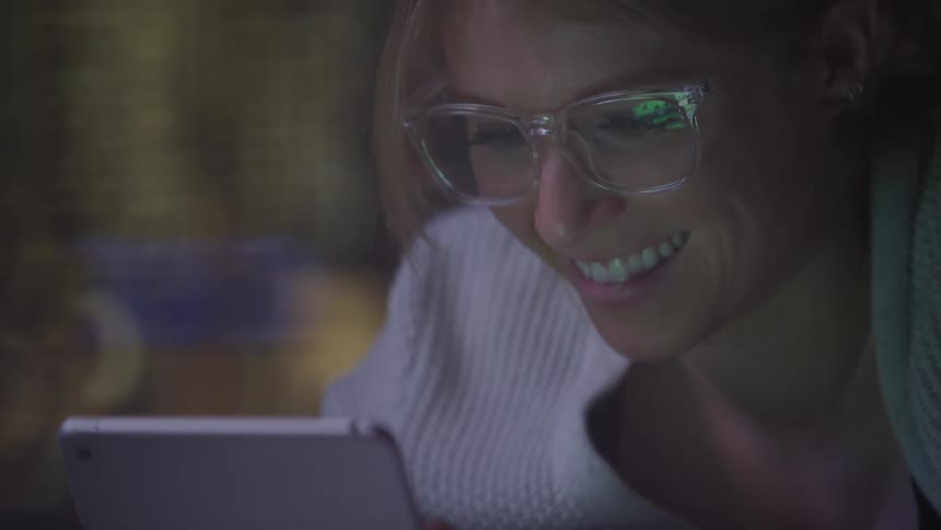 Lady looking at a cell phone and smiling