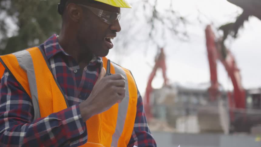 Working man communicating with walkie talkie